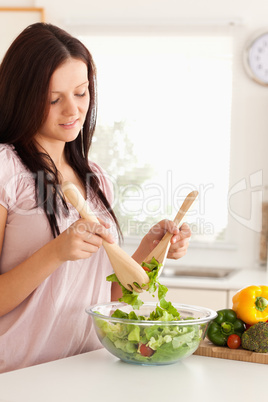 Smiling woman mixing a salad