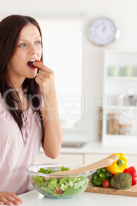 Portrait of a joyful woman eating vegetables