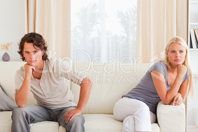 Upset couple sitting on a sofa