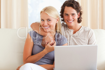 Friendly couple holding a laptop