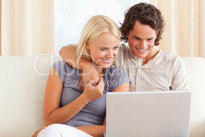 Smiling young couple using a laptop