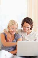 Portrait of a smiling young couple using a laptop