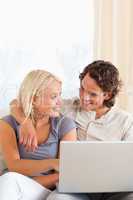 Portrait of a cute young couple using a laptop