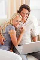 Portrait of a happy young couple using a laptop