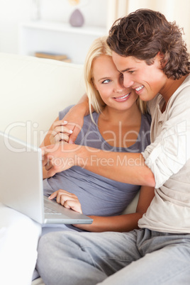 Portrait of a man showing something to his wife on a laptop