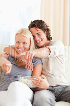 Portrait of a couple watching TV while eating popcorn