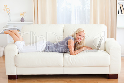 Woman lying on a sofa with a notebook