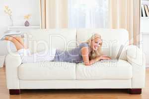 Woman lying on a sofa with a notebook