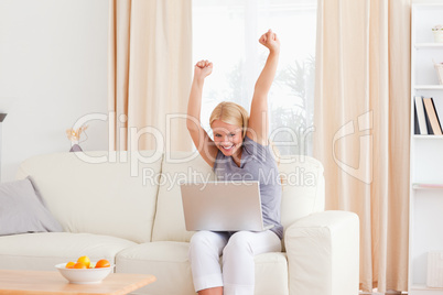 Cheerful blonde woman using a laptop