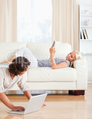 Portrait of a man with a laptop while his wife is with a book