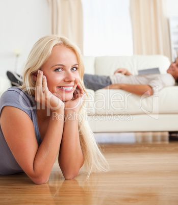 Portrait of a woman lying on the floor while her husband is with