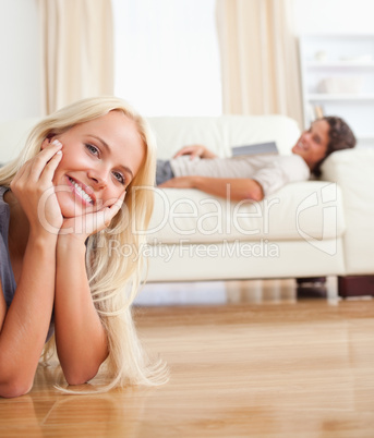 Portrait of a woman lying on the floor while her fiance is with