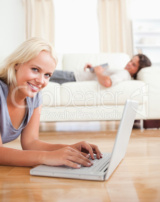 Portrait of a woman using a notebook while her husband is readin