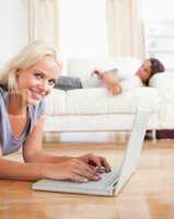 Portrait of a woman using a notebook while her husband is readin