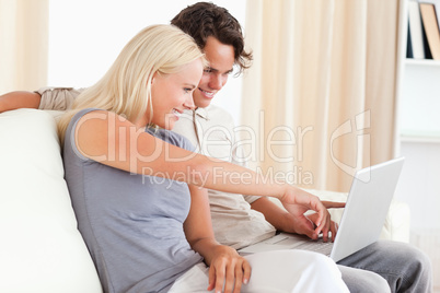 Woman pointing at something to her fiance on a screen