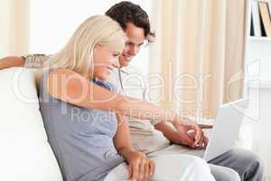 Woman pointing at something to her fiance on a screen