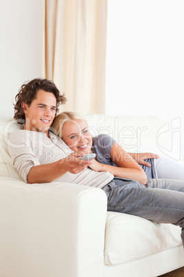 Portrait of a couple cuddling while watching TV