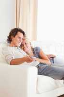 Portrait of a cute couple cuddling while watching TV