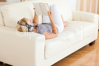 Woman listenning to music while reading a book