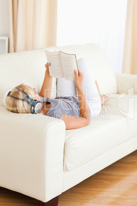 Portrait of a woman listenning to music while reading a book