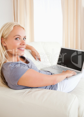 Portrait of a blonde woman switching on her laptop