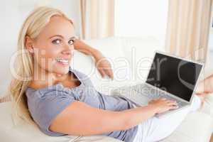 Blonde woman switching on her laptop