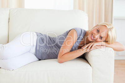 Smiling woman resting on a sofa