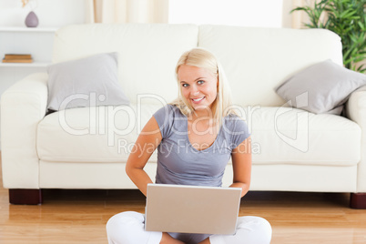 Happy woman with a notebook while sitting on the floor