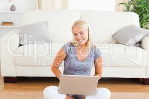 Happy woman with a notebook while sitting on the floor