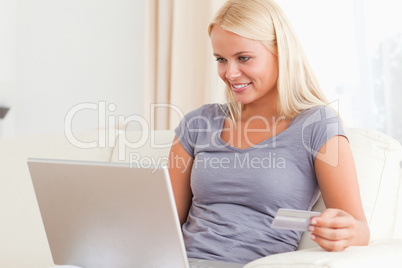 Woman looking at her laptop while holding  her credit card