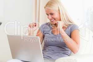 Woman cheering in front of a laptop