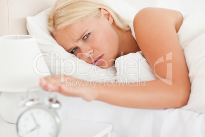 Cute woman awaken by an alarmclock