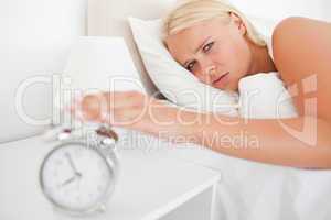 Tired woman awaken by an alarmclock