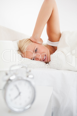 Portrait of an alarmclock waking up a woman