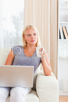 Portrait of a woman having a coffee while holding a laptop Portrait of a woman having a coffee while holding a laptop
