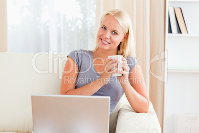 Woman having a coffee while holding a notebook