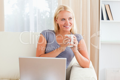 Woman having a tea while holding a notebook