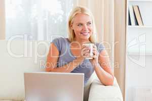 Woman having a tea while holding a notebook