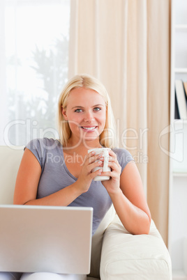 Portrait of a woman having a tea with a notebook