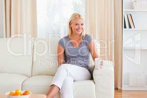 Woman sitting on a sofa with a cup of tea
