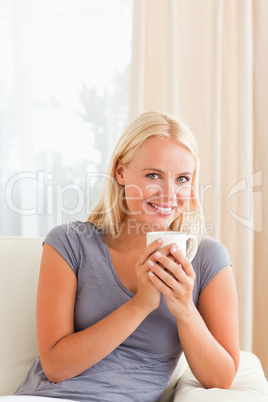 Portrait of a woman sitting on a couch with a cup of tea