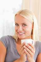 Portrait of a woman sitting on a couch with a cup of coffee