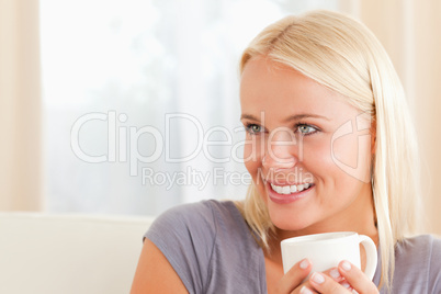 Close up of a woman sitting on a couch with a cup of tea
