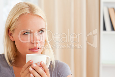 Close up of a woman sitting on a sofa with a cup of tea