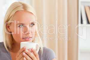 Close up of a woman sitting on a sofa with a cup of tea