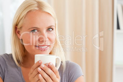 Calm woman sitting on a couch with a cup of tea