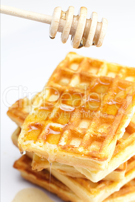 delicious Belgian waffles and stick to honey isolated on white