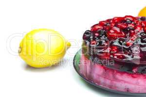 beautiful cake with berries on a plate and lemon isolated on whi