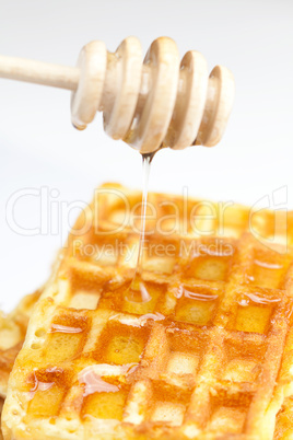 delicious Belgian waffles and stick to honey isolated on white