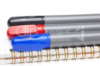 colored markers and a notebook isolated on white